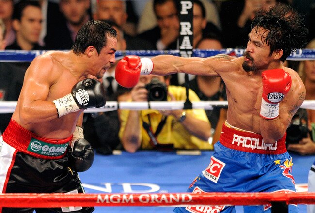 LAS VEGAS, NV - NOVEMBER 12:  Manny Pacquiao (R) throws a right at Juan Manuel Marquez during the seventh round of their WBO world welterweight title fight at the MGM Grand Garden Arena November 12, 2011 in Las Vegas, Nevada. Pacquiao retained his title with a majority decision victory.  (Photo by Ethan Miller/Getty Images)