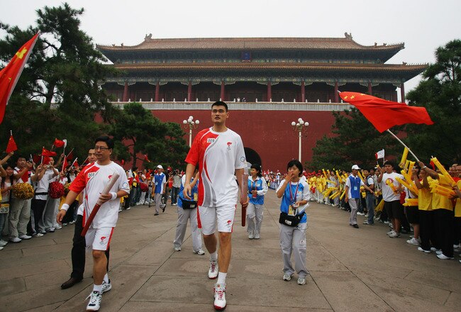 BEIJING - AUGUST 06:  China's NBA star Yao Ming carries the Olympic torch before the start of the Olympic torch relay on Tiananmen Square on August 6, 2008 in Beijing, China.  (Photo by Feng Li/Getty Images)