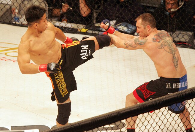 Cung Le (left) delivers a kick to opponent Brian Warren during the StrikeForce mixed martial arts event at HP Pavilion on June 9, 2006 in San Jose, California (Photo by John Medina/Getty Images)