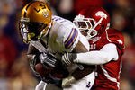 BATON ROUGE, LA - NOVEMBER 28:  Brandon LaFell #1 of the LSU Tigers is tackled by Jerell Norton #27 of the Arkansa Razorbacks at Tiger Stadium on November 28, 2009 in Baton Rouge, Louisiana.  The Tigers defeated the Razorbacks 33-30 in overtime.  (Photo by Chris Graythen/Getty Images)