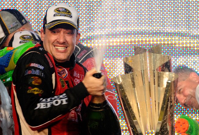HOMESTEAD, FL - NOVEMBER 20:  Tony Stewart, driver of the #14 Office Depot/Mobil 1 Chevrolet, celebrates with the trophy in Victory Lane after winning the NASCAR Sprint Cup Series Ford 400 and the 2011 Series Championship at Homestead-Miami Speedway on November 20, 2011 in Homestead, Florida. Stewart wins his third NASCAR Championship.  (Photo by Jared C. Tilton/Getty Images)