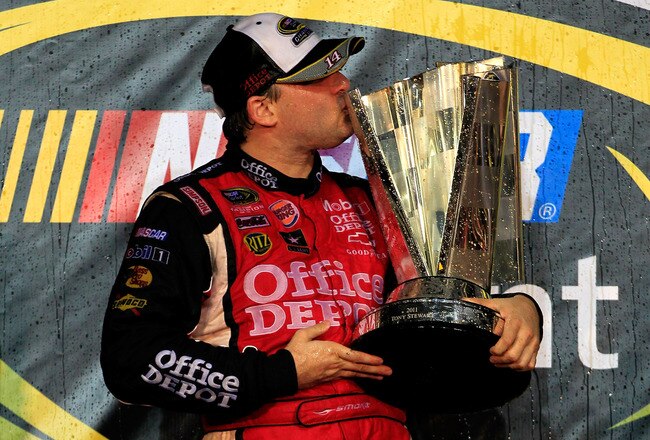 HOMESTEAD, FL - NOVEMBER 20:  Tony Stewart, driver of the #14 Office Depot/Mobil 1 Chevrolet, celebrates with the trophy in Victory Lane after winning the NASCAR Sprint Cup Series Ford 400 and the 2011 Series Championship at Homestead-Miami Speedway on November 20, 2011 in Homestead, Florida. Stewart wins his third NASCAR Championship.  (Photo by Chris Trotman/Getty Images for NASCAR)