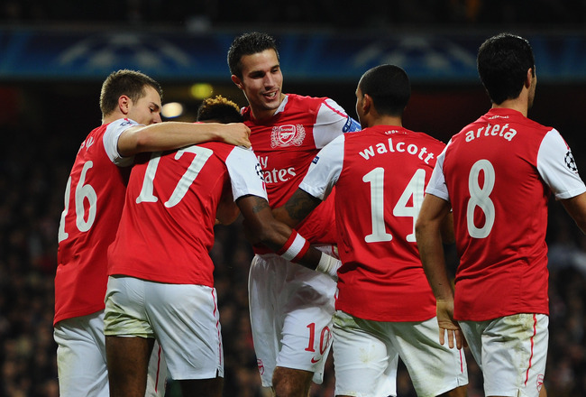 LONDON, ENGLAND - NOVEMBER 23:  Robin van Persie of Arsenal is congratulated by team mates after scoring the opening goal during the UEFA Champions League Group F match between Arsenal FC and Borussia Dortmund  at Emirates Stadium on November 23, 2011 in London, England.  (Photo by Mike Hewitt/Getty Images)