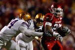 BATON ROUGE, LA - NOVEMBER 28:  Ronnie Wingo Jr. #20 of the Arkansas Razorbacks avoids a tackle by Harry Coleman #24 and Rahim Alem #84 of the LSU Tigers at Tiger Stadium on November 28, 2009 in Baton Rouge, Louisiana.  The Tigers defeated the Razorbacks 33-30 in overtime.  (Photo by Chris Graythen/Getty Images)
