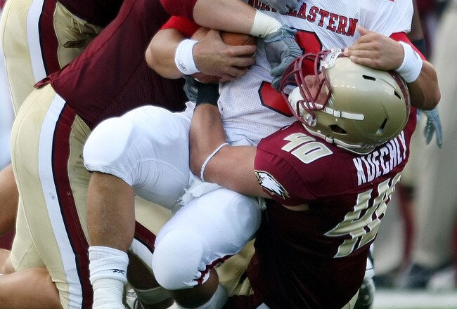 CHESTNUT HILL, MA - SEPTEMBER 05:  Matt Carroll #3 of the Northeastern Huskies is tackled by Dillon Quinn #92,Kaleb Ramsey #96 and Luke Kuechly #40  of the Boston College Eagles on September 5, 2009 at Alumni Stadium in Chestnut Hill, Massachusetts.  (Photo by Elsa/Getty Images)