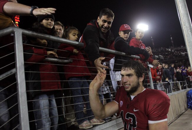 STANFORD, CA - NOVEMBER 26:  Andrew Luck #12 of the Stanford Cardinal high fives with fans in the crowd as he leaves the field after beating the Notre Dame Fighting Irish at Stanford Stadium on November 26, 2011 in Stanford, California.  (Photo by Ezra Shaw/Getty Images)