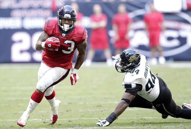 HOUSTON - OCTOBER 30:  Running back Arian Foster #23 of the Houston Texans avoids a tackle attempt by defensive lineman Jeremy Mincey #94 of the Jacksonville Jaguars at Reliant Stadium on October 30, 2011 in Houston, Texas.  (Photo by Bob Levey/Getty Images)