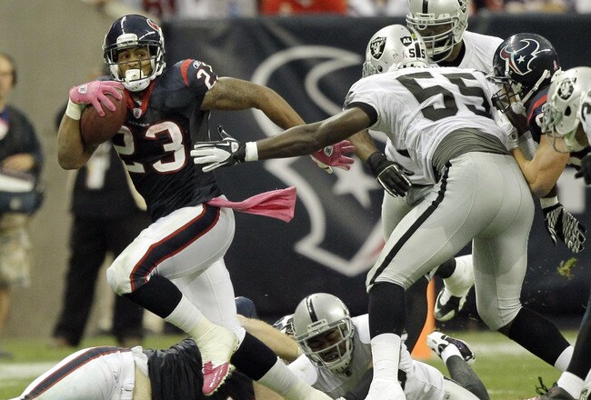 HOUSTON - OCTOBER 09:  Running back Arian Foster #23 of the Houston Texans breaks a tackle by linebacker Rolando McClain #55 of the Oakland Raiders at Reliant Stadium on October 9, 2011 in Houston, Texas.  (Photo by Bob Levey/Getty Images)