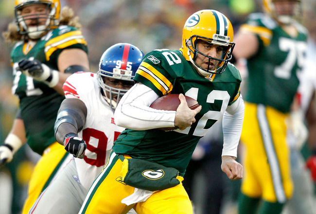 GREEN BAY, WI - DECEMBER 26:  Aaron Rodgers #12 of the Green Bay Packers is chased out of the pocket against the New York Giants at Lambeau Field on December 26, 2010 in Green Bay, Wisconsin.  (Photo by Matthew Stockman/Getty Images)