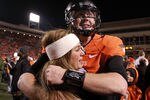 STILLWATER, OK - DECEMBER 03:  Brandon Weeden #3 of the Oklahoma State Cowboys hugs his wife, Melanie Weeden after a 44-10 win against the Oklahoma Sooners at Boone Pickens Stadium on December 3, 2011 in Stillwater, Oklahoma.  (Photo by Ronald Martinez/Getty Images)