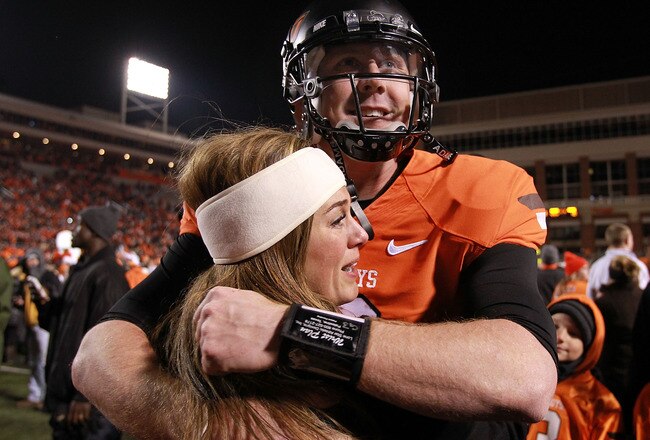 STILLWATER, OK - DECEMBER 03:  Brandon Weeden #3 of the Oklahoma State Cowboys hugs his wife, Melanie Weeden after a 44-10 win against the Oklahoma Sooners at Boone Pickens Stadium on December 3, 2011 in Stillwater, Oklahoma.  (Photo by Ronald Martinez/Getty Images)