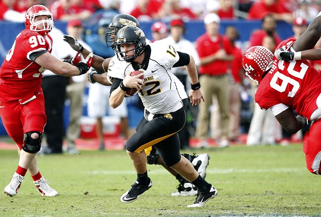 HOUSTON - DECEMBER 03:  Quarterback Austin Davis #12 of the Southern Miss Golden Eagles looks for room to run against the Houston Cougars at Robertson Stadium on December 3, 2011 in Houston, Texas.  (Photo by Bob Levey/Getty Images)