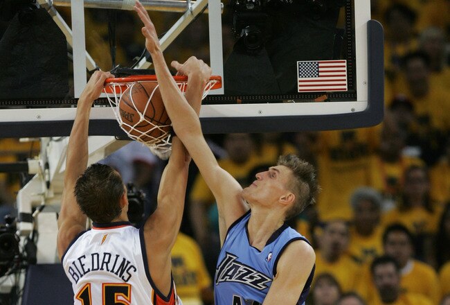 OAKLAND, CA - MAY 11:  Andris Biedrins #15 of the Golden State Warriors makes a slam-dunk against Andrei Kirilenko #47 of the Utah Jazz in Game Three of the Western Conference Semifinals during the 2007 NBA Playoffs at Oracle Arena May 11, 2007 in Oakland, California. NOTE TO USER: User expressly acknowledges and agrees that, by downloading and or using this photograph, user is consenting to the terms and conditions of the Getty Images License Agreement.  (Photo by Justin Sullivan/Getty Images)