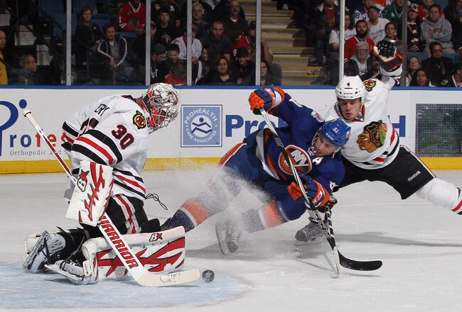 UNIONDALE, NY - DECEMBER 08: Ray Emery #30 and defenseman Niklas Hjalmarsson #4 of the Chicago Blackhawks defend against John Tavares #91 of the New York Islanders at the Nassau Veterans Memorial Coliseum on December 8, 2011 in Uniondale, New York.  (Photo by Bruce Bennett/Getty Images)