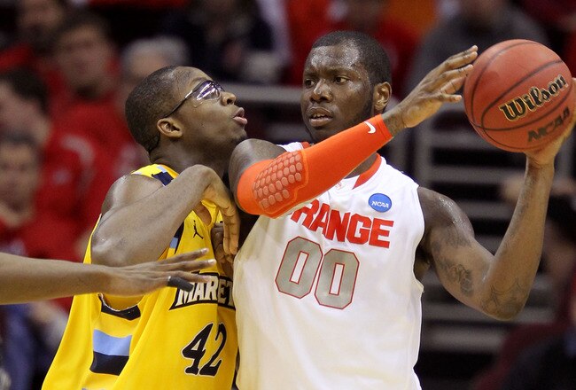 CLEVELAND, OH - MARCH 20: Rick Jackson #00 of the Syracuse Orange handles the ball against Chris Otule #42 of the Marquette Golden Eagles during the third of the 2011 NCAA men's basketball tournament at Quicken Loans Arena on March 20, 2011 in Cleveland, Ohio.  (Photo by Andy Lyons/Getty Images)