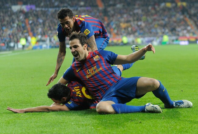 MADRID, SPAIN - DECEMBER 10:  Xavi Hernandez of Barcelona celebrates with Cesc Fabregas (R) after Barcelona scoring Barcelona's 2nd goal during the La Liga match between Real Madrid and Barcelona at Estadio Santiago Bernabeu on December 10, 2011 in Madrid, Spain.  (Photo by Denis Doyle/Getty Images)