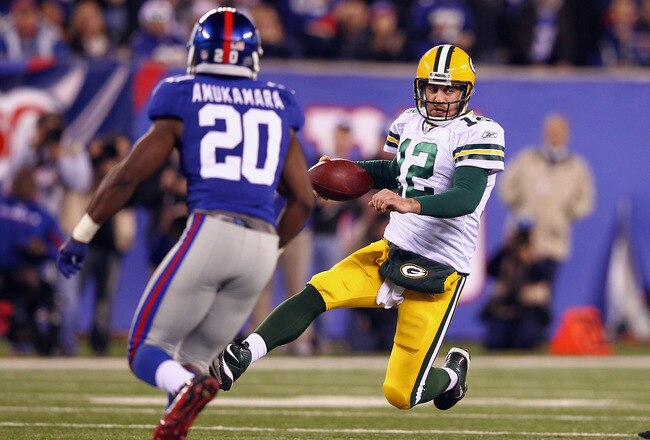 EAST RUTHERFORD, NJ - DECEMBER 04:  Aaron Rodgers #12 of the Green Bay Packers slides to the turf against Prince Amukamara #20 of the New York Giants at MetLife Stadium on December 4, 2011 in East Rutherford, New Jersey.  (Photo by Al Bello/Getty Images)