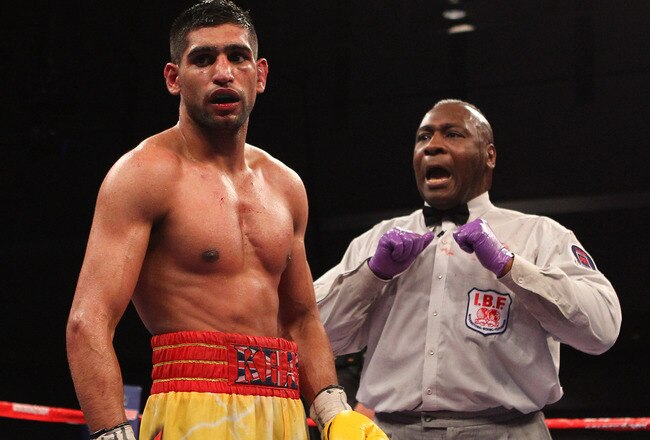 WASHINGTON, DC - DECEMBER 10:  Referee Joe Cooper deducts a point from Amir Khan for excessive shoving against Lamont Peterson during their WBA Super Lightweight and IBF Junior Welterweight title fight at Washington Convention Center on December 10, 2011 in Washington, DC.  (Photo by Al Bello/Getty Images)