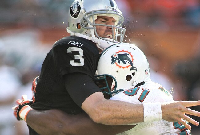 MIAMI GARDENS, FL - DECEMBER 04:  Linebacker Cameron Wake #91 of the Miami Dolphins hits Quarterback Carson Plamer #3 of the Oakland Raiders at Sun Life Stadium on December 4, 2011 in Miami Gardens, Florida.  Miami defeated the Raiders 34-14. (Photo by Marc Serota/Getty Images)