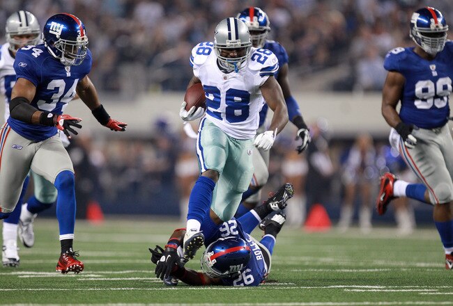 ARLINGTON, TX - DECEMBER 11:  Running back Felix Jones #28 of the Dallas Cowboys runs the ball as he break a tackle by Antrel Rolle #26 of the New York Giants for a 26-yard gain in the first quarter at Cowboys Stadium on December 11, 2011 in Arlington, Texas.  (Photo by Ronald Martinez/Getty Images)
