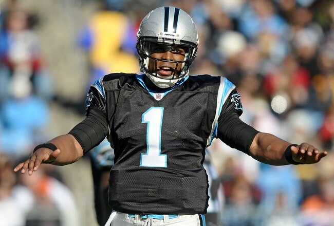 CHARLOTTE, NC - DECEMBER 11:  Quarterback Cam Newton #1 of the Carolina Panthers stretches his arms during the game against the Atlanta Falcons at Bank of America Stadium on December 11, 2011 in Charlotte, North Carolina.  (Photo by Jared C. Tilton/Getty Images)