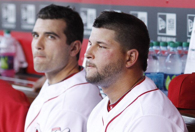 CINCINNATI, OH - AUGUST 29: Yonder Alonso #23 and Joey Votto #19 of the Cincinnati Reds look on from the dugout during the game against the Philadelphia Phillies at Great American Ball Park on August 29, 2011 in Cincinnati, Ohio. (Photo by Joe Robbins/Getty Images)