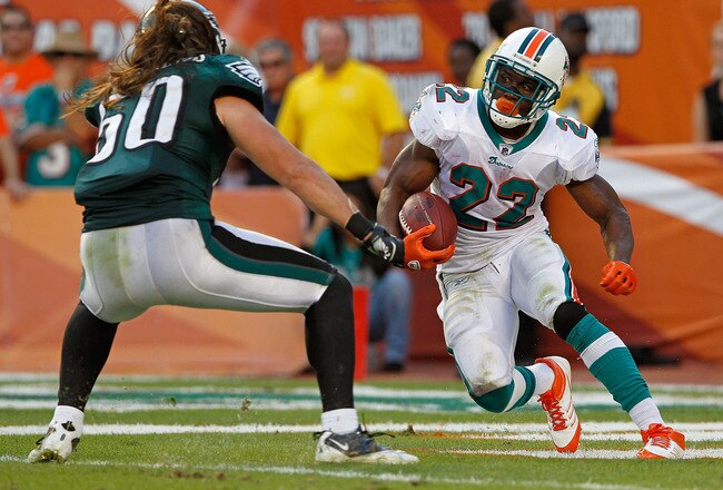 MIAMI GARDENS, FL - DECEMBER 11:  Reggie Bush #22 of the Miami Dolphins runs away from Casey Matthews #50 of the Philadelphia Eagles during a game  at Sun Life Stadium on December 11, 2011 in Miami Gardens, Florida.  (Photo by Mike Ehrmann/Getty Images)