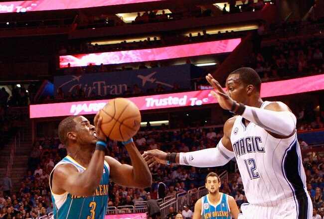 ORLANDO, FL - OCTOBER 10:  Chris Paul #3 of the New Orleans Hornets attempts a shot against Dwight Howard #12 of the Orlando Magic during the game at Amway Arena on October 10, 2010 in Orlando, Florida. NOTE TO USER: User expressly acknowledges and agrees that, by downloading and or using this Photograph, user is consenting to the terms and conditions of the Getty Images License Agreement.  (Photo by Sam Greenwood/Getty Images)
