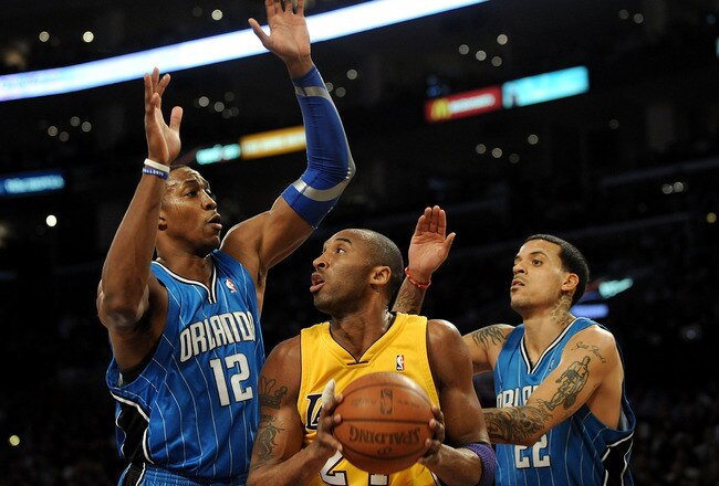 LOS ANGELES, CA - JANUARY 18:  Kobe Bryant #24 of the Los Angeles Lakers handles the ball against Dwight Howard #12 and Matt Barnes #22 of the Orlando Magic in the first quarter during the game on January 18, 2010 at Staples Center in Los Angeles, California. NOTE TO USER: User expressly acknowledges and agrees that, by downloading and/or using this Photograph, user is consenting to the terms and conditions of the Getty Images License Agreement.  (Photo by Harry How/Getty Images)