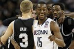 HOUSTON, TX - APRIL 04:  Kemba Walker #15 of the Connecticut Huskies smiles as the Butler Bulldogs huddle during the National Championship Game of the 2011 NCAA Division I Men's Basketball Tournament at Reliant Stadium on April 4, 2011 in Houston, Texas.  (Photo by Ronald Martinez/Getty Images)