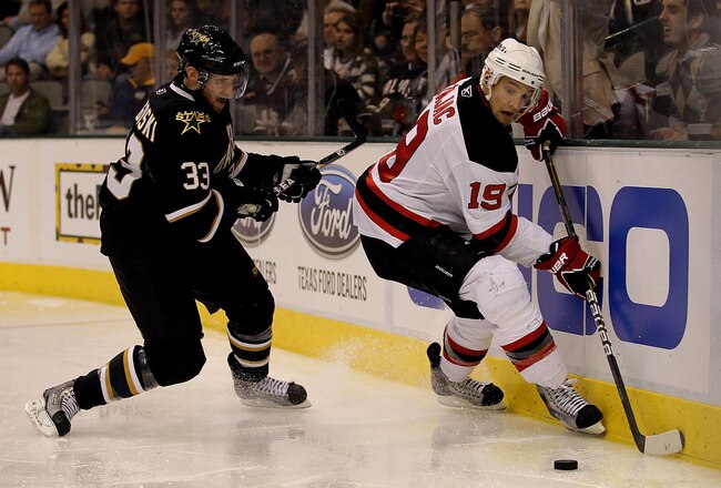DALLAS, TX - FEBRUARY 22:  Center Travis Zajac #19 of the New Jersey Devils skates the puck against Alex Goligoski #33 of the Dallas Stars at American Airlines Center on February 22, 2011 in Dallas, Texas.  (Photo by Ronald Martinez/Getty Images)