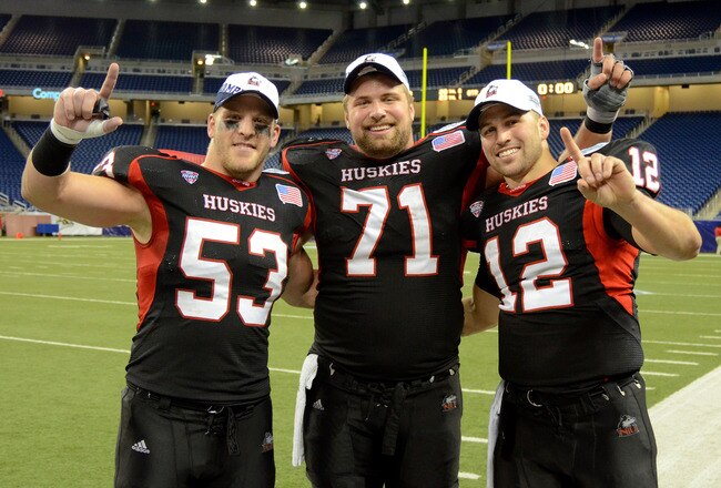 DETROIT, MI - DECEMBER 02:  Pat Schiller #53, Scott Wedige #71 and Chandler Harnish #12 of the Northern Illinois Huskies pose for a photo after winning the MAC Championship game against the Ohio Bobcats at Ford Field on December 2, 2011 in Detroit, Michigan. The Huskies defeated the Bobcats 23-20.  (Photo by Mark A. Cunningham/Getty Images)