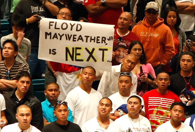 LAS VEGAS - MAY 01:  A sign for Floyd Mayweather Jr. is held as boxing fans wait for the official weigh-in for the junior welterweight title fight between Ricky Hatton of England and Manny Pacquiao of the Philippines at the MGM Grand Garden Arena May 1, 2009 in Las Vegas, Nevada. It was reported that on May 2 Mayweather will announce the end of his retirement to fight Juan Manuel Marquez.  (Photo by Ethan Miller/Getty Images)