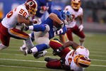 EAST RUTHERFORD, NJ - DECEMBER 18:   Henry Hynoski #45 of the New York Giants is tackled by  Perry Riley #56 and  London Fletcher #59 of the Washington Redskins during their game at MetLife Stadium on December 18, 2011 in East Rutherford, New Jersey.  (Photo by Al Bello/Getty Images)