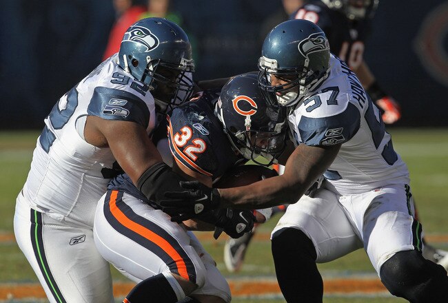 CHICAGO, IL - DECEMBER 18: Kahlil Bell #32 of the Chicago Bears is tackled by Brandon Mebane #92 and David Hawthorne #57 of the Seattle Seahawks at Soldier Field on December18, 2011 in Chicago, Illinois. The Seahawks defeated the Bears 38-14.(Photo by Jonathan Daniel/Getty Images)