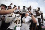 HOUSTON - DECEMBER 03:  Quarterback Austin Davis #12 (L) and Tim Green #43 and teammates of the Southern Miss Golden Eagles celebrate with the Conference USA trophy after defeating the Houston Cougars 49-28 at Robertson Stadium on December 3, 2011 in Houston, Texas.  (Photo by Bob Levey/Getty Images)