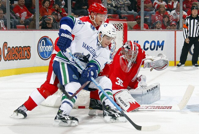 DETROIT MI - OCTOBER 13:  Alexandre Burrows #14 of the Vancouver Canucks attempts a wrap around on Jimmy Howard #35 of the Detroit Red Wings as Nicklas Lidstrom #5 of the Red Wings defends during their NHL game at Joe Louis Arena October13, 2011 in Detroit, Michigan.  (Photo by Dave Sandford/Getty Images)