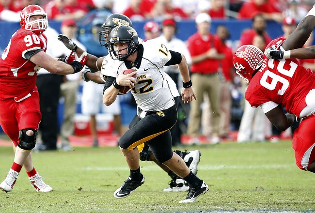 HOUSTON - DECEMBER 03:  Quarterback Austin Davis #12 of the Southern Miss Golden Eagles looks for room to run against the Houston Cougars at Robertson Stadium on December 3, 2011 in Houston, Texas.  (Photo by Bob Levey/Getty Images)