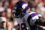 LANDOVER, MD - NOVEMBER 28: Running back Adrian Peterson #28 of the Minnesota Vikings stiff arms Philip Buchanon #31 the Washington Redskins at FedExField November 28, 2010 in Landover, Maryland. The Vikings won the game 17-13. (Photo by Win McNamee/Getty Images)