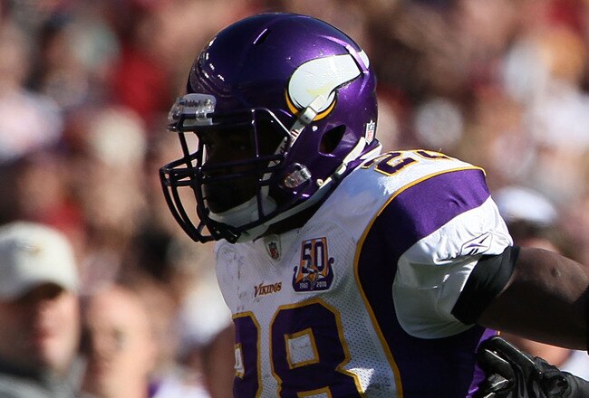 LANDOVER, MD - NOVEMBER 28: Running back Adrian Peterson #28 of the Minnesota Vikings stiff arms Philip Buchanon #31 the Washington Redskins at FedExField November 28, 2010 in Landover, Maryland. The Vikings won the game 17-13. (Photo by Win McNamee/Getty Images)