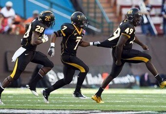 Southernmissgoldeneaglesplayersfromleftjacoriuscottondesmondjohnsonandcordarrolawcelebrateafourthdownstopofthenevadawolfpackduringthe2011hawaiibowlatalohastadium