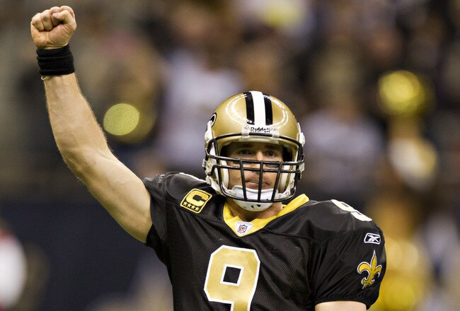 NEW ORLEANS, LA - DECEMBER 26:   Quarterback Drew Brees #9 of the New Orleans Saints celebrates after throwing a nine-yard touchdown pass to running back Darren Sproles #43 and broke the single-season passing record in the fourth quarter against the Atlanta Falcons at Mercedes-Benz Superdome on December 26, 2011 in New Orleans, Louisiana.  The Saints defeated the Falcons 45-16.  (Photo by Wesley Hitt/Getty Images)