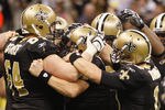 NEW ORLEANS, LA - DECEMBER 26:  Quarterback Drew Brees #9 of the New Orleans Saints is surrounded by his team after Brees throws a nine-yard touchdown pass to running back Darren Sproles #43 and breaks the single-season passing record in the fourth quarter against the Atlanta Falcons at the Mercedes-Benz Superdome on December 26, 2011 in New Orleans, Louisiana.   (Photo by Chris Graythen/Getty Images)