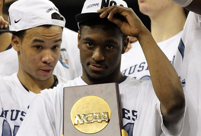 HOUSTON, TX - APRIL 04:  Kemba Walker #15 of the Connecticut Huskies holds the trophy as he and his team celebrate after defeating the Butler Bulldogs to win the National Championship Game of the 2011 NCAA Division I Men's Basketball Tournament by a score of 53-41 at Reliant Stadium on April 4, 2011 in Houston, Texas.  (Photo by Ronald Martinez/Getty Images)