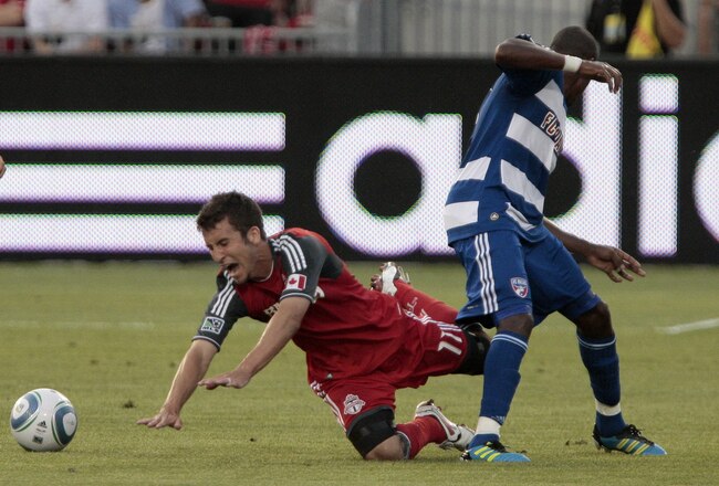 TORONTO, CANADA - JULY 20: Nathan Sturgis #11 of Toronto FC is taken out by Jackson Goncalves #6 of FC Dallas during MLS action at BMO Field July 20, 2011 in Toronto, Ontario, Canada. (Photo by Abelimages/Getty Images)
