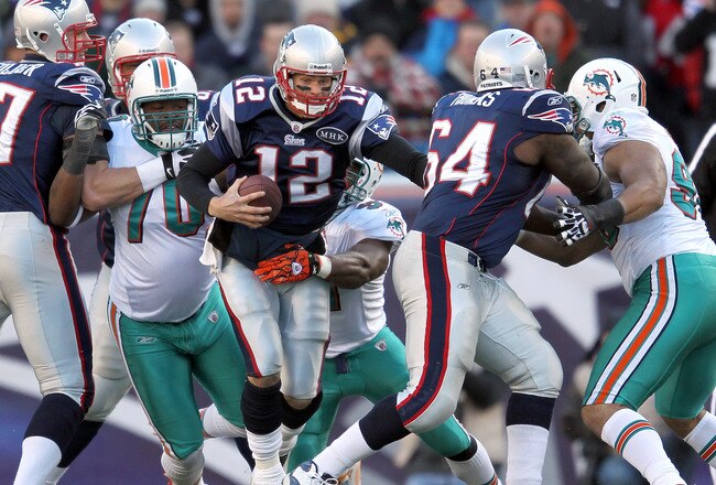 FOXBORO, MA - DECEMBER 24:   Tom Brady #12 of the New England Patriots feels pressure during a game against the Miami Dolphins at Gillette Stadium on December 24, 2011 in Foxboro, Massachusetts. (Photo by Jim Rogash/Getty Images)