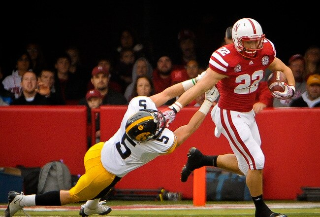 LINCOLN, NE - NOVEMBER 25: Running back Rex Burkhead #22 of the Nebraska Cornhuskers stiff-arms defensive back Tanner Miller #5 of the Iowa Hawkeyes during their game at Memorial Stadium November 25, 2011 in Lincoln, Nebraska. (Photo by Eric Francis/Getty Images)