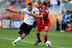 PORT ELIZABETH, SOUTH AFRICA - JUNE 18:  Lukas Podolski of Germany tussles with Zdravko Kuzmanovic of Serbia during the 2010 FIFA World Cup South Africa Group D match between Germany and Serbia at Nelson Mandela Bay Stadium on June 18, 2010 in Port Elizabeth, South Africa.  (Photo by Joern Pollex/Getty Images)