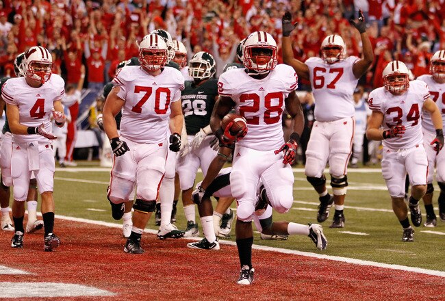 INDIANAPOLIS, IN - DECEMBER 03:  Montee Ball #28 of the Wisconsin Badgers celebrates along with his teammates afte he scored his second 6-yard rushing touchdown in the first quarter against the Michigan State Spartans during the Big 10 Conference Championship Game at Lucas Oil Stadium on December 3, 2011 in Indianapolis, Indiana.  (Photo by Gregory Shamus/Getty Images)
