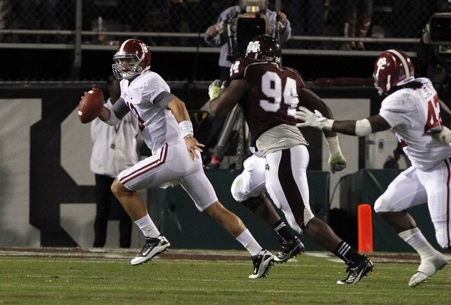 STARKVILLE, MS - NOVEMBER 12:  quarterback AJ McCarron #10 of the Alabama Crimson Tide scrambles away from pressure from defensive lineman Fletcher Cox #94 of the Mississippi State Bulldogs on November 12, 2011 at Davis Wade Stadium in Starkville, Mississippi. Alabama won 24-7. (Photo by Butch Dill/Getty Images)